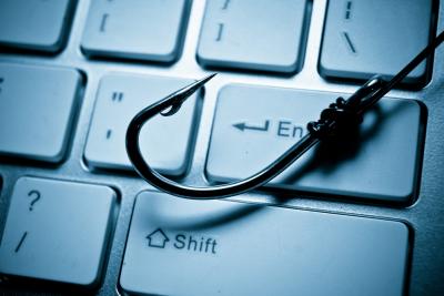 Fishing hook on computer keyboard to symbolise phishing