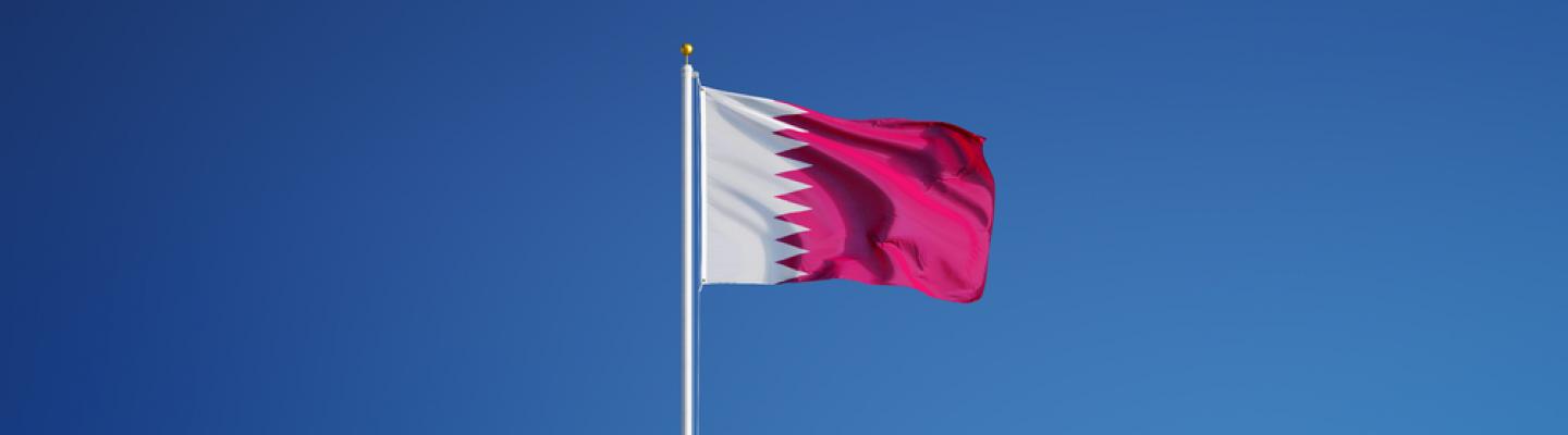 Flag of Qatar against blue sky