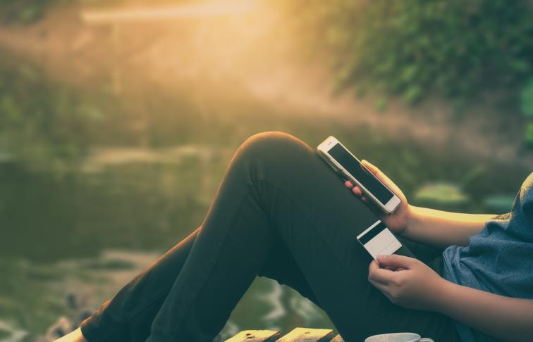 Woman banking through her mobile phone