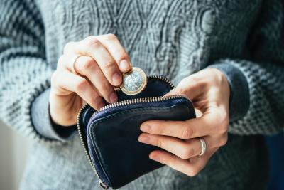 Woman putting two pounds in her purse