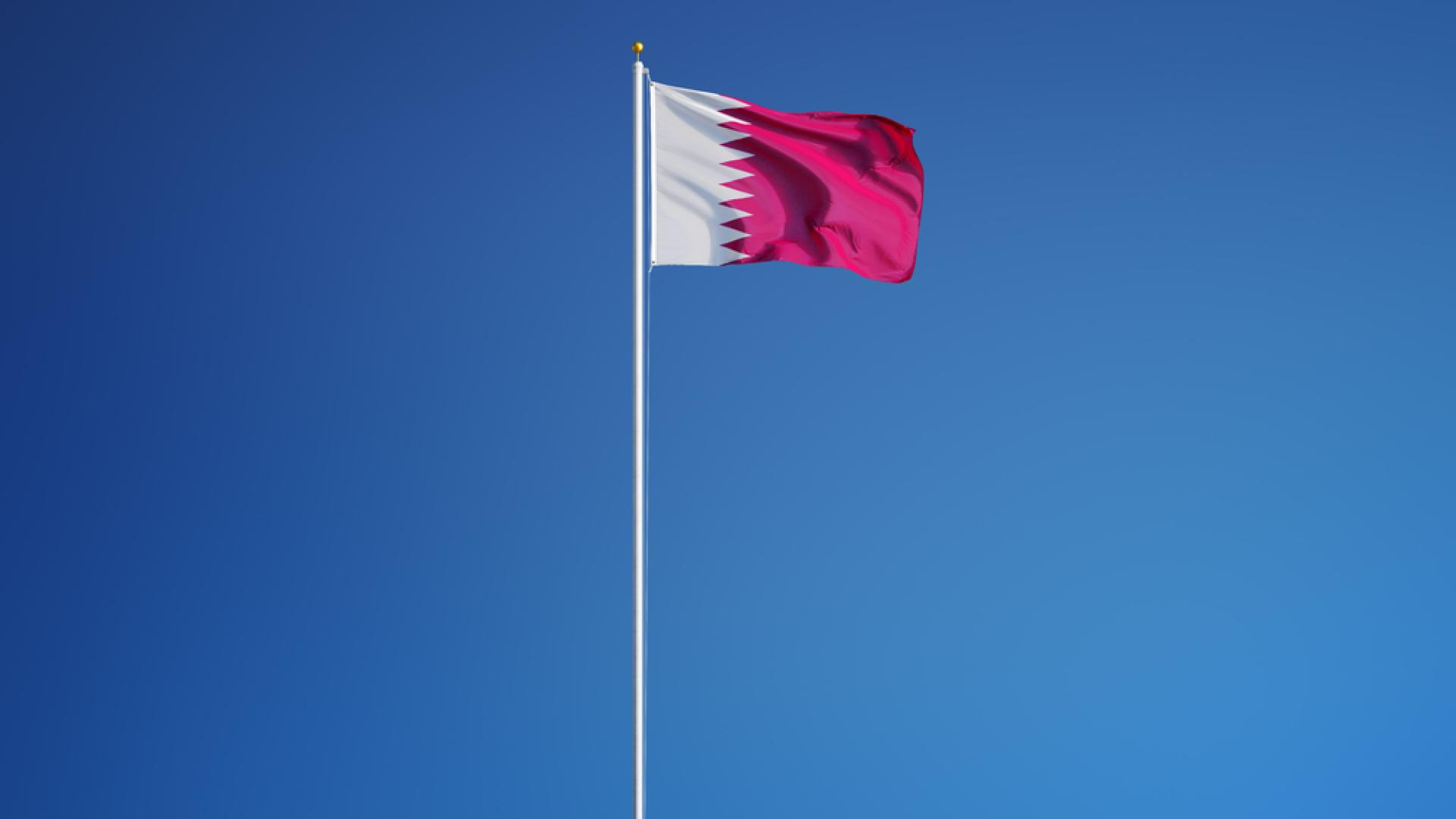 Flag of Qatar against blue sky