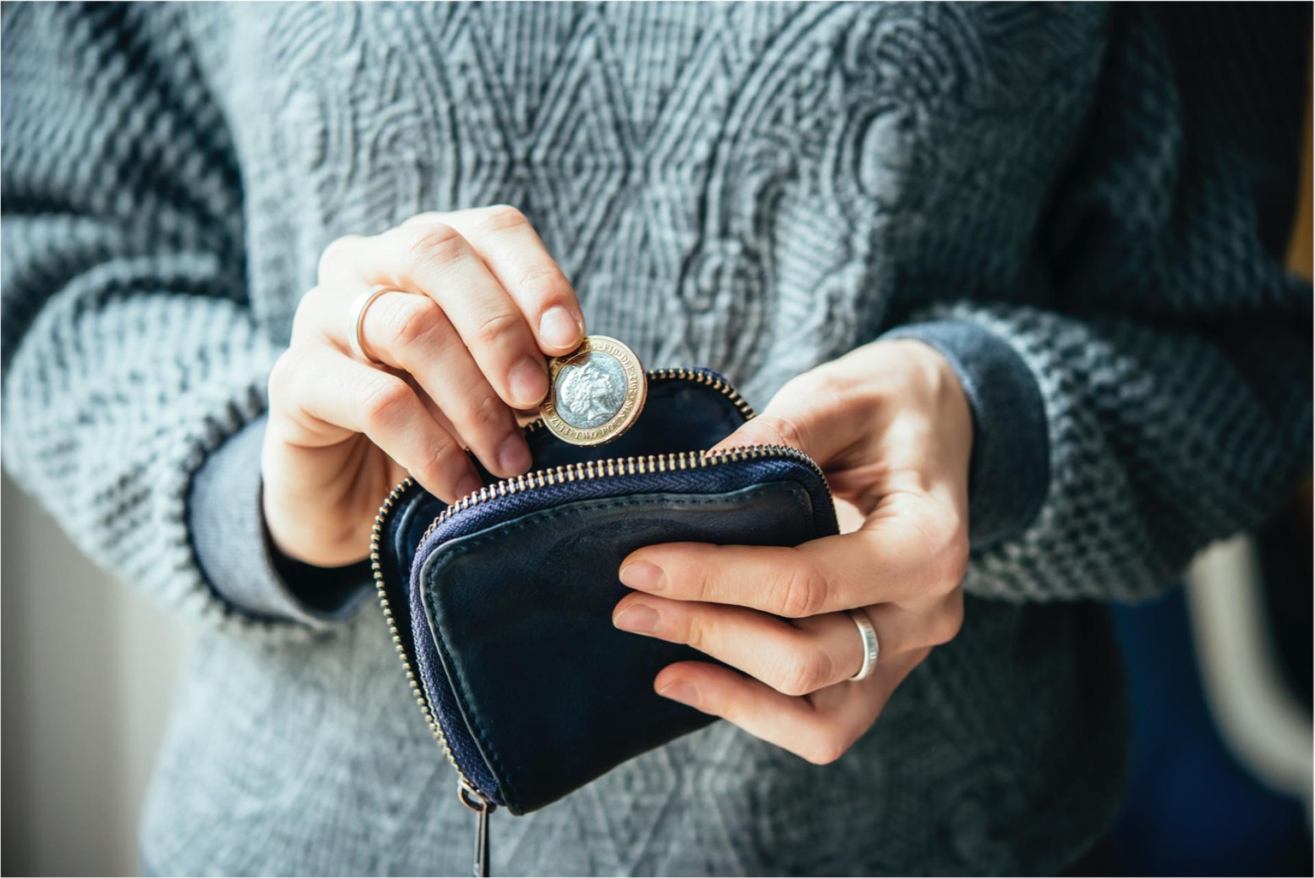 Woman putting two pounds in her purse