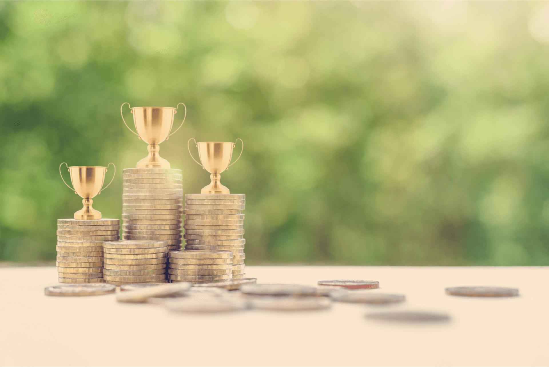 Stacks of coins with trophies on top