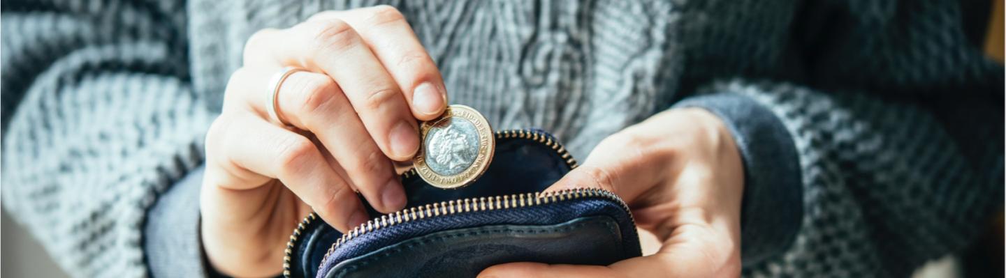 Woman putting two pounds in her purse