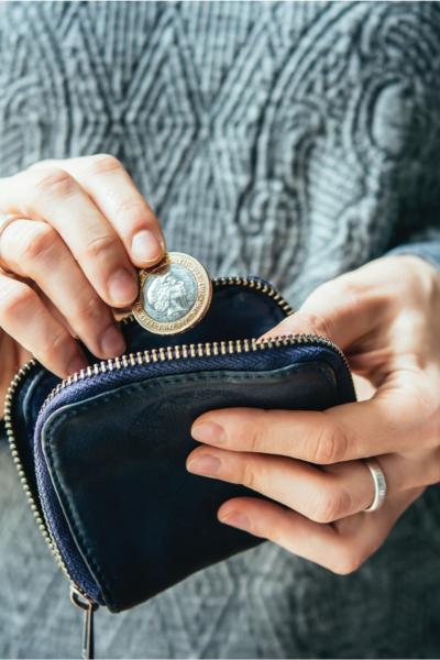 Woman putting two pounds in her purse